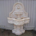 Deruta Lemon Wall Fountain in action against beige wall.